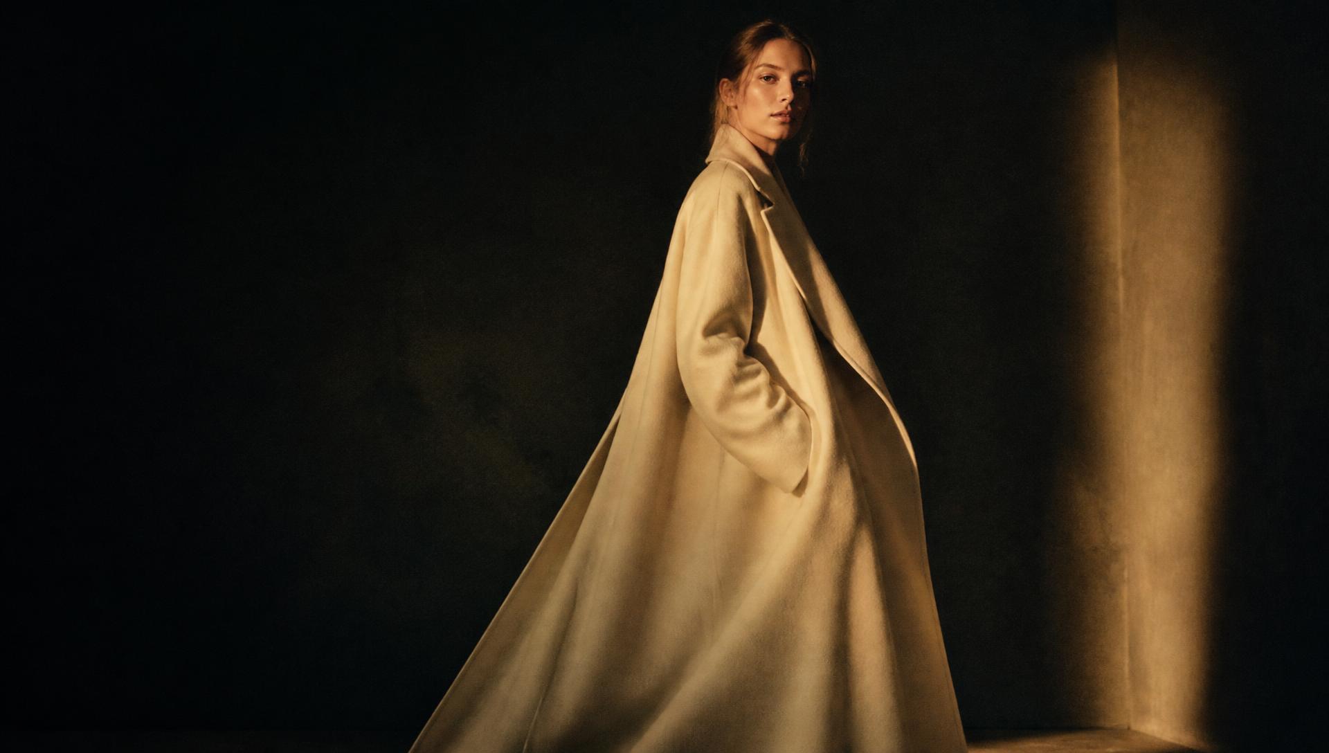 Kamoura campaign — ivory wool coat in low light
